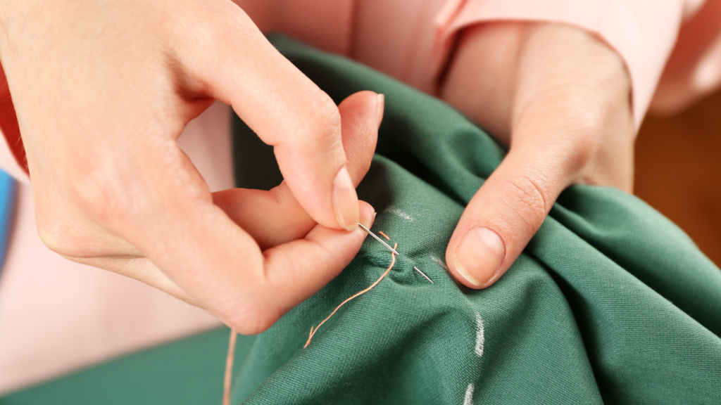 Woman hand sewing scraps of fabric together